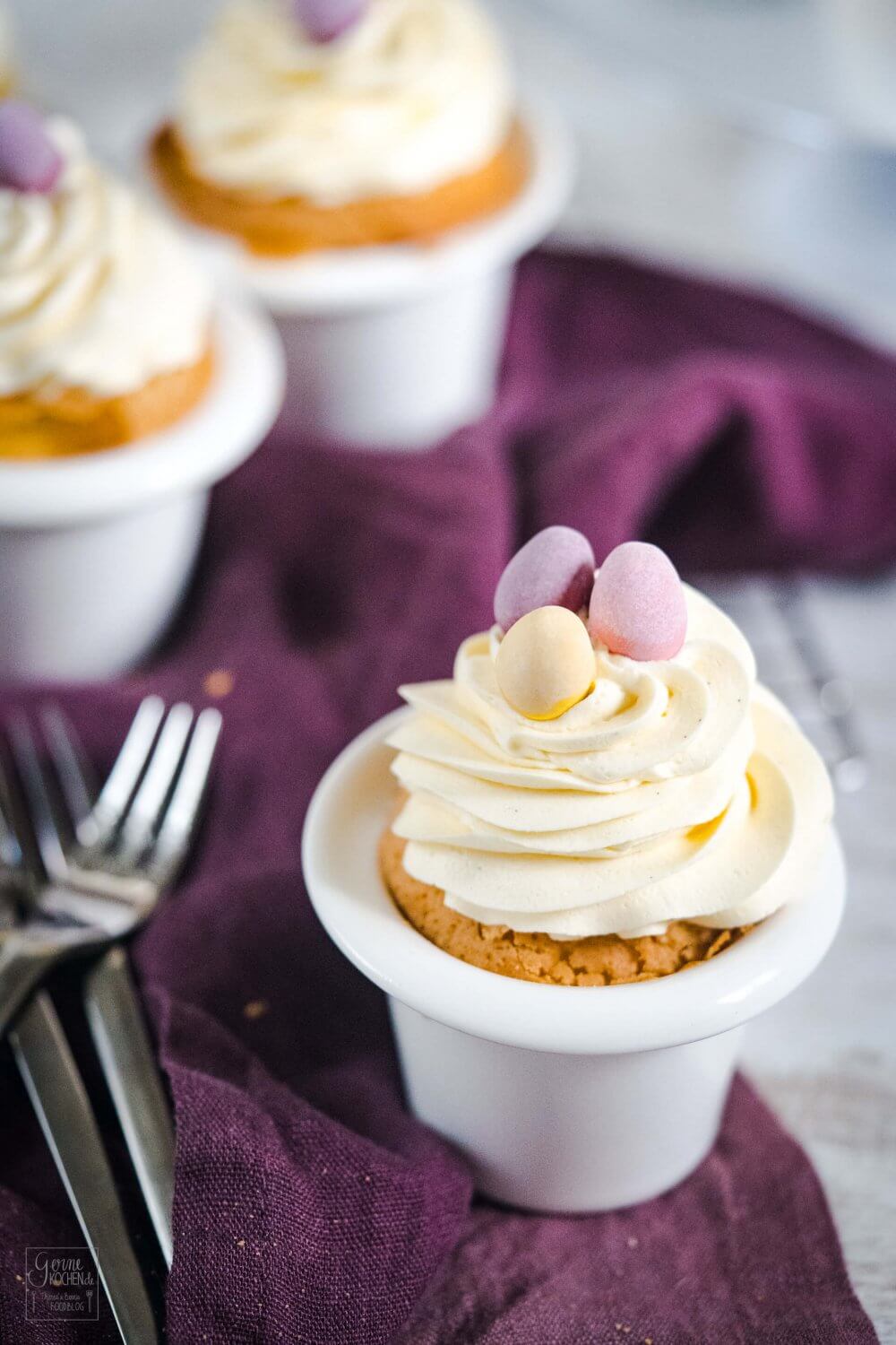 Eierlikör Cupcakes mit süßen Pastell-Schokoeiern als Hingucker.