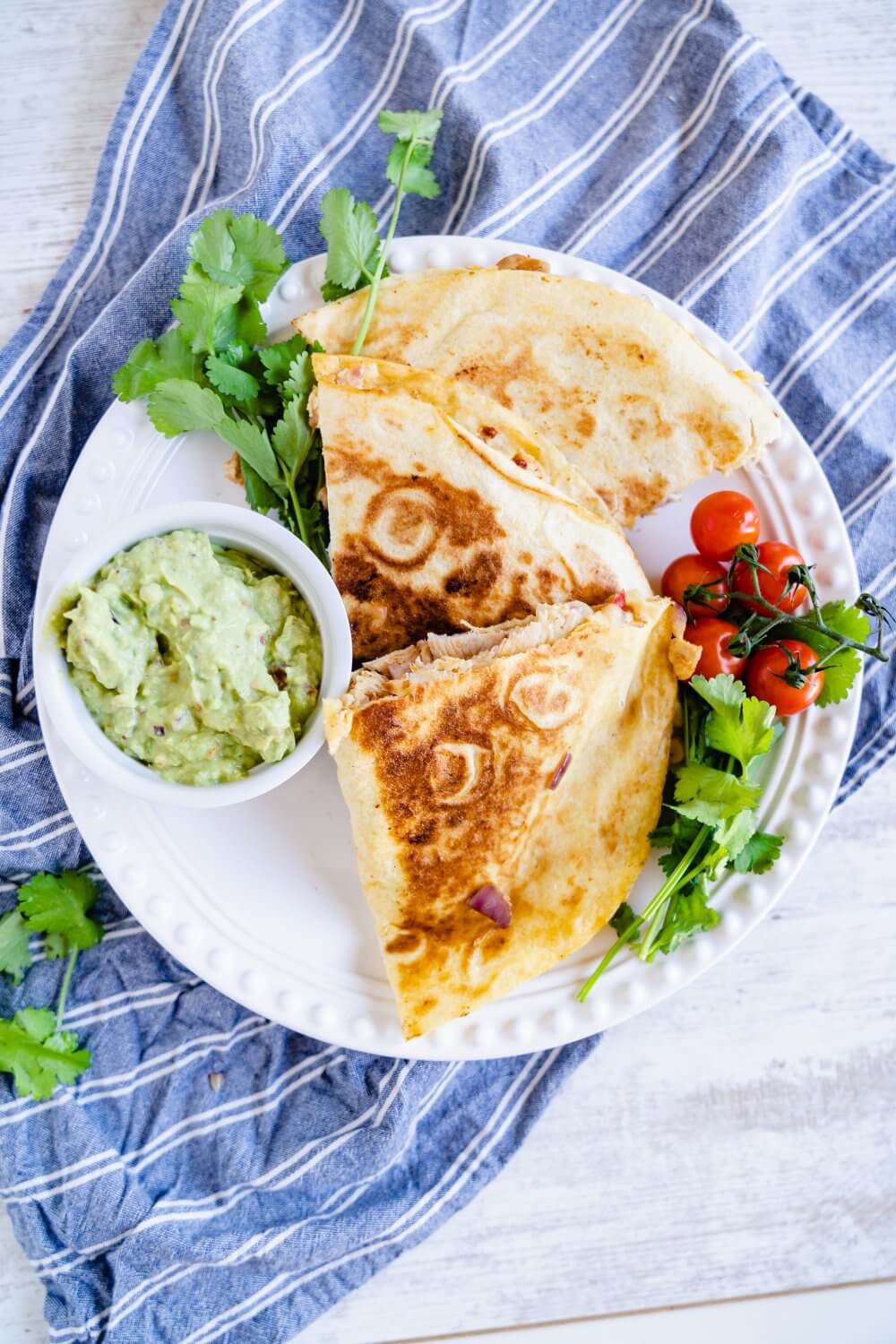Mexikanische Maisfladen, gefüllt mit Hähnchen und roter Paprika. Verfeinert mit frischer Guacamole und Koriander.