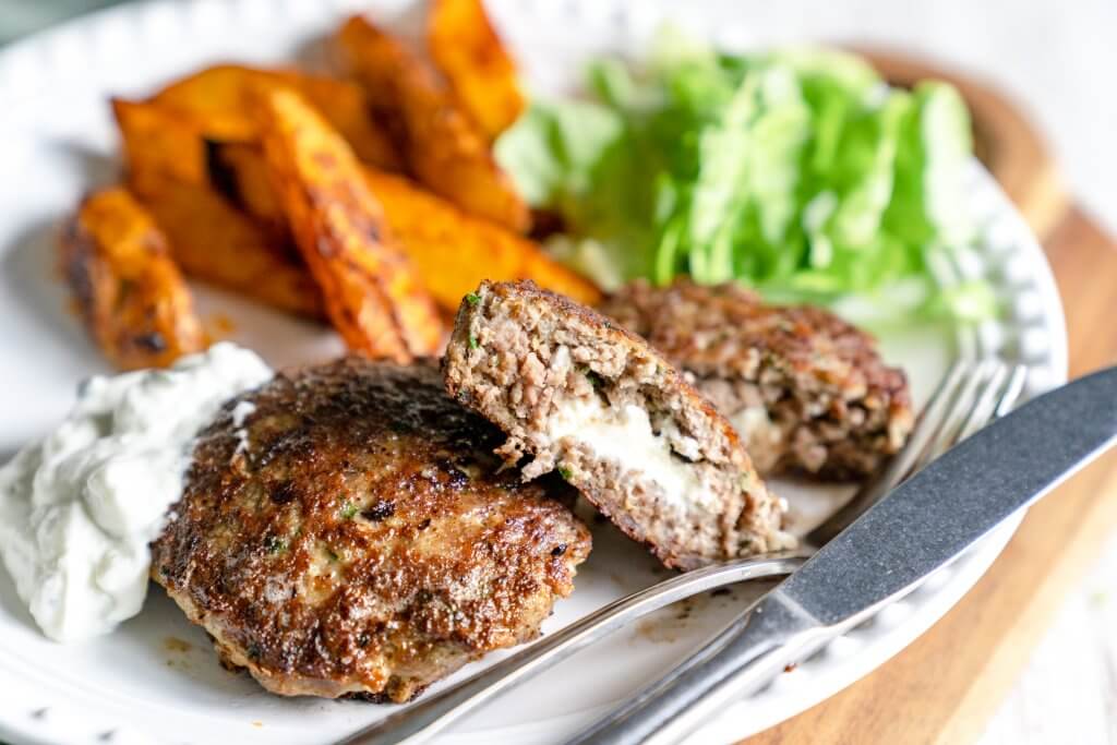 Leckeres Biefteki, eine aus Hackfleisch gefertigte griechische Spezialität, ergänzt mit Salat, Zaziki und Kartoffelecken.