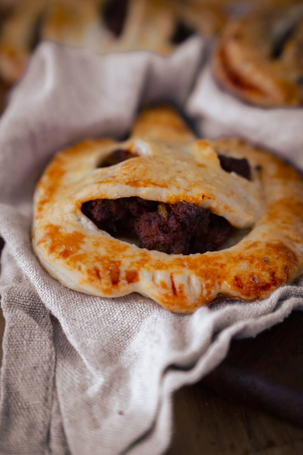 Ein witziges Lächeln in die Kürbis Empanadas geschnitzt und schon sind sie ein echter Hingucker auf jeder Tafel.