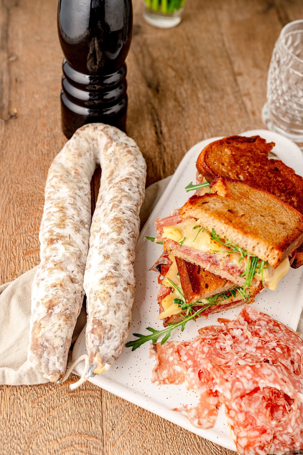 Eine Aoste Ringsalami, unser Croque Aoste und hauchdünn aufgeschnittene Aoste Ringsalami aus einer schrägen Perspektive