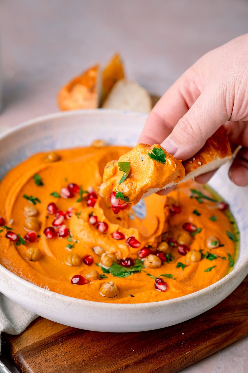 Leckeres Hummus-Dip mit Granatapfelkernen und Koriander, serviert mit Fladenbrot.