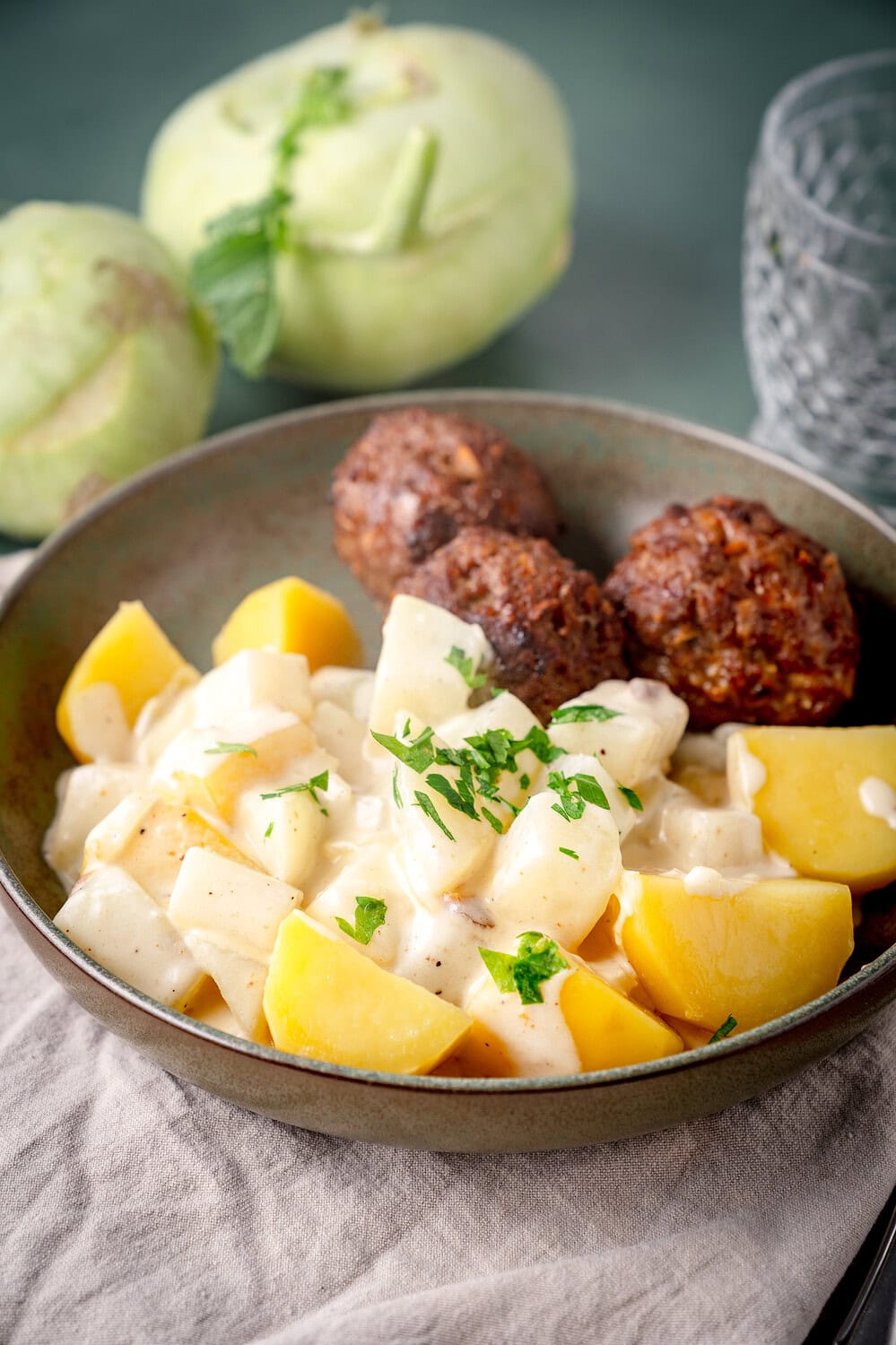 Rahm Kohlrabi in Milchsauce auf grünem Teller mit Frikadellen