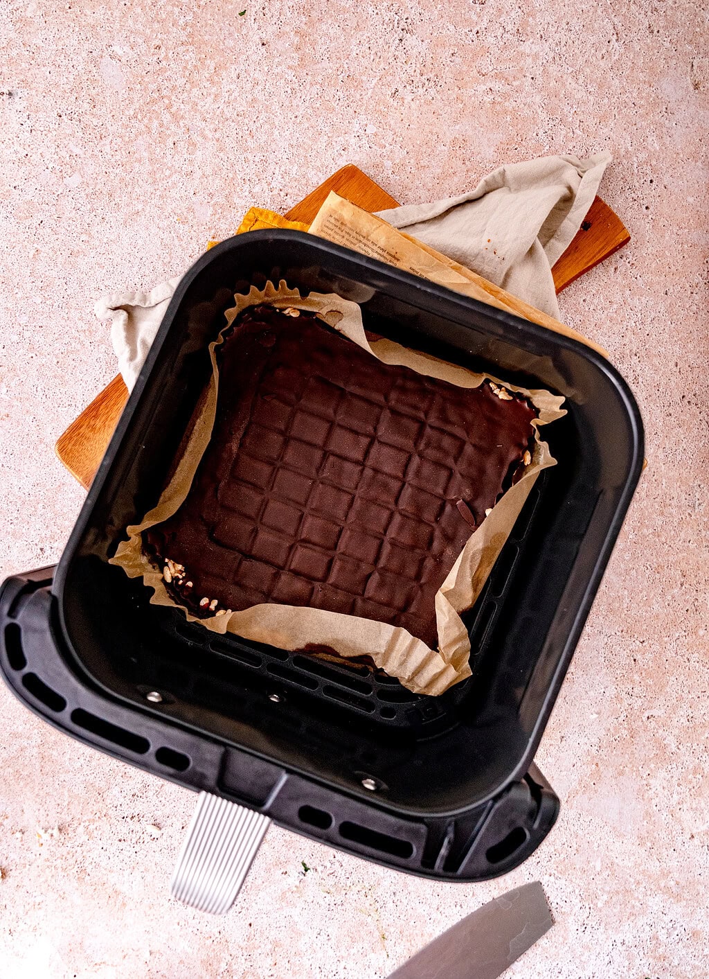 Puffreis Schokolade aus der Heißluftfritteuse und Backpapier ausgelegt.