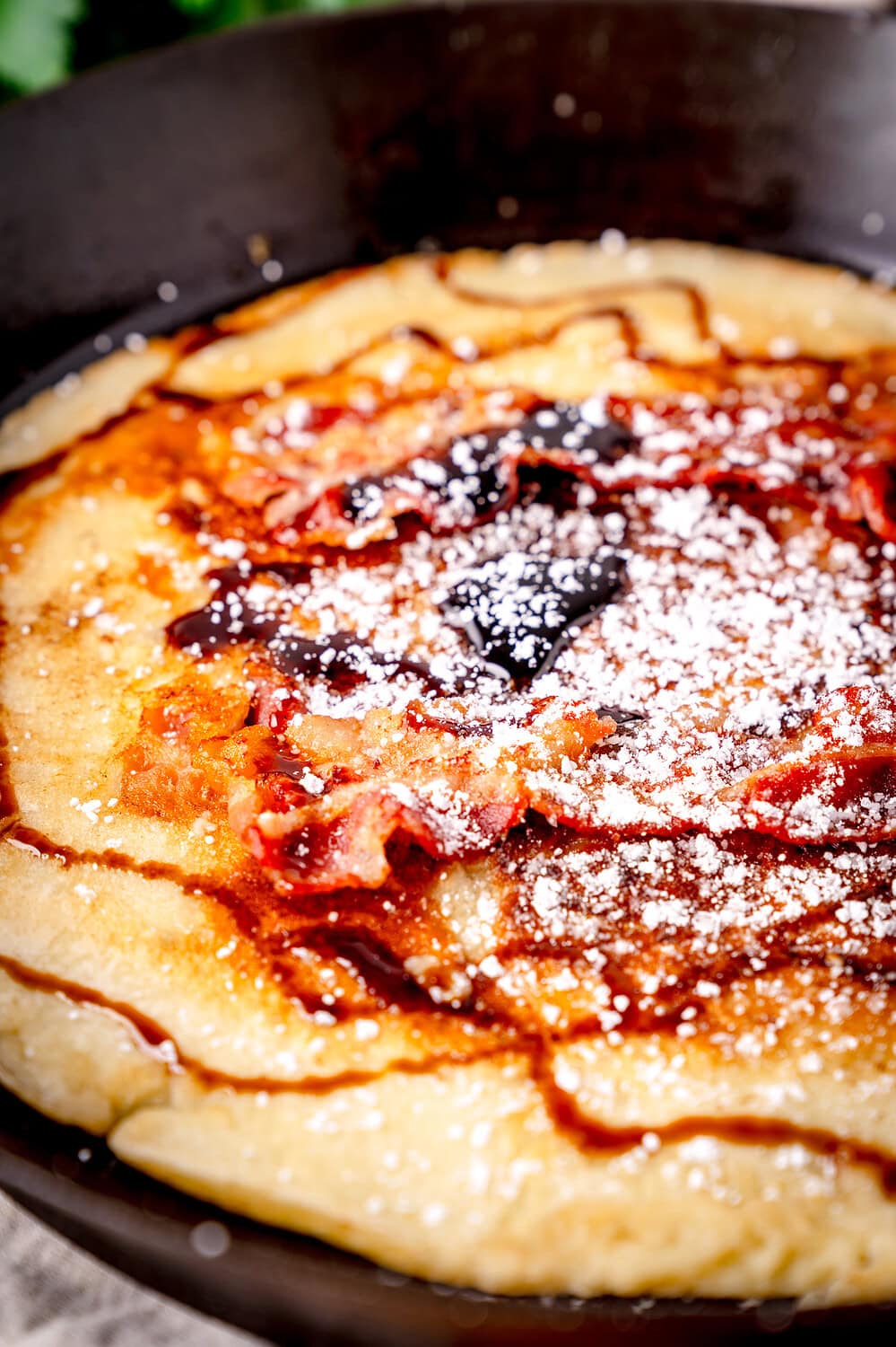 Leckeres Speckpfannkuchen-Rezept mit Puderzucker und Zuckerrübensirup.