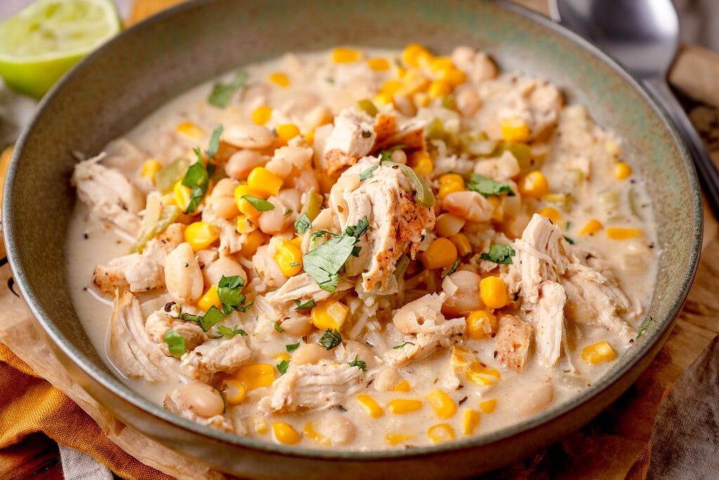 Leckeres White Chicken Chili mit Mais, Bohnen und frischen Kräutern in Frischkäsesauce.