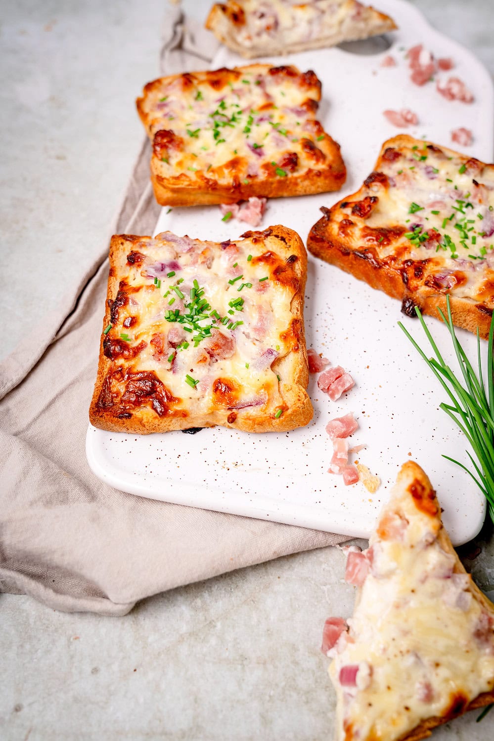 Einfache Flammkuchentoast mit Speck, Zwiebeln und Schnittlauch.