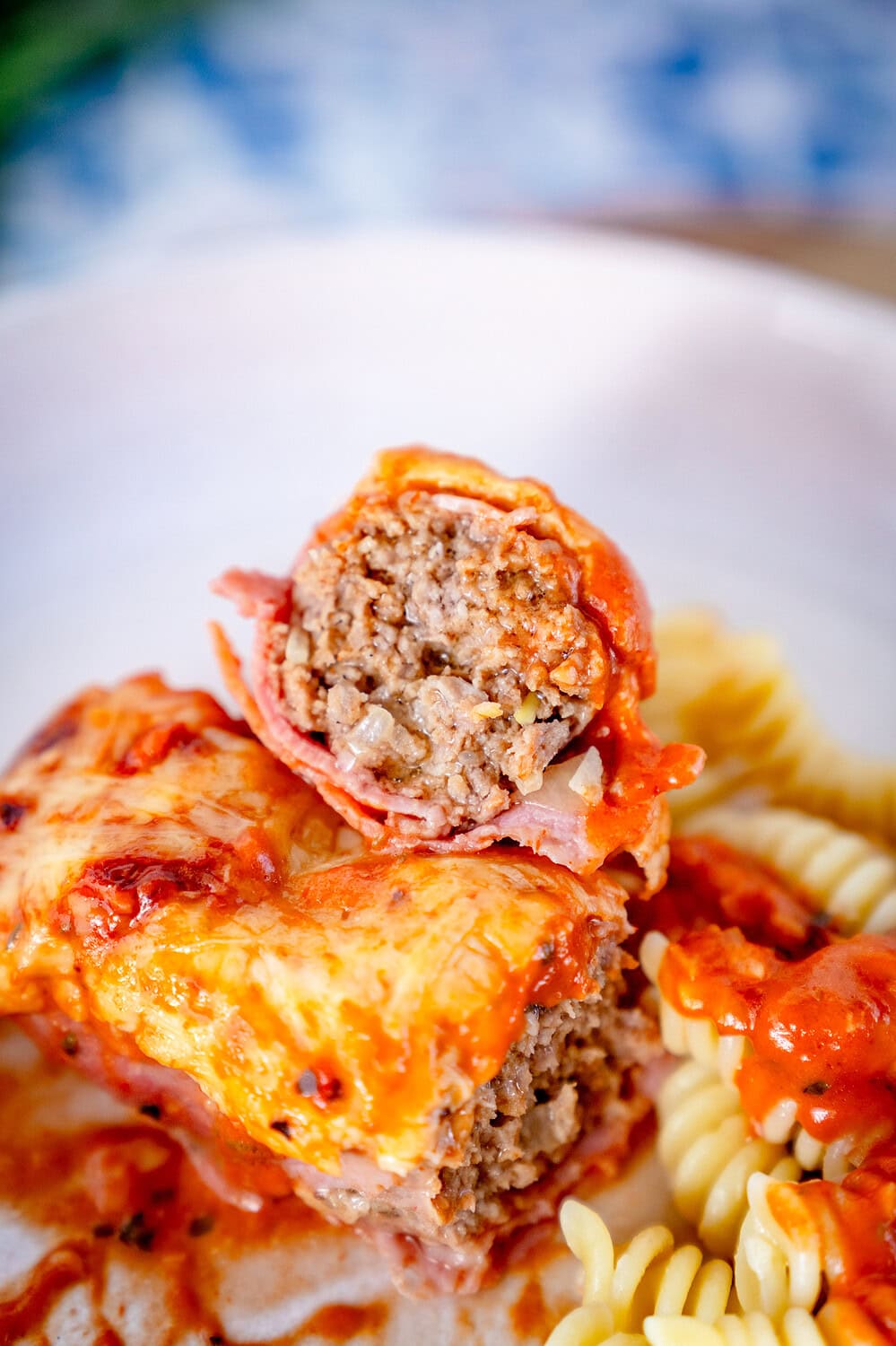 Aufgeschnittene Schinken-Hackröllchen mit Tomaten-Sahne-Sauce