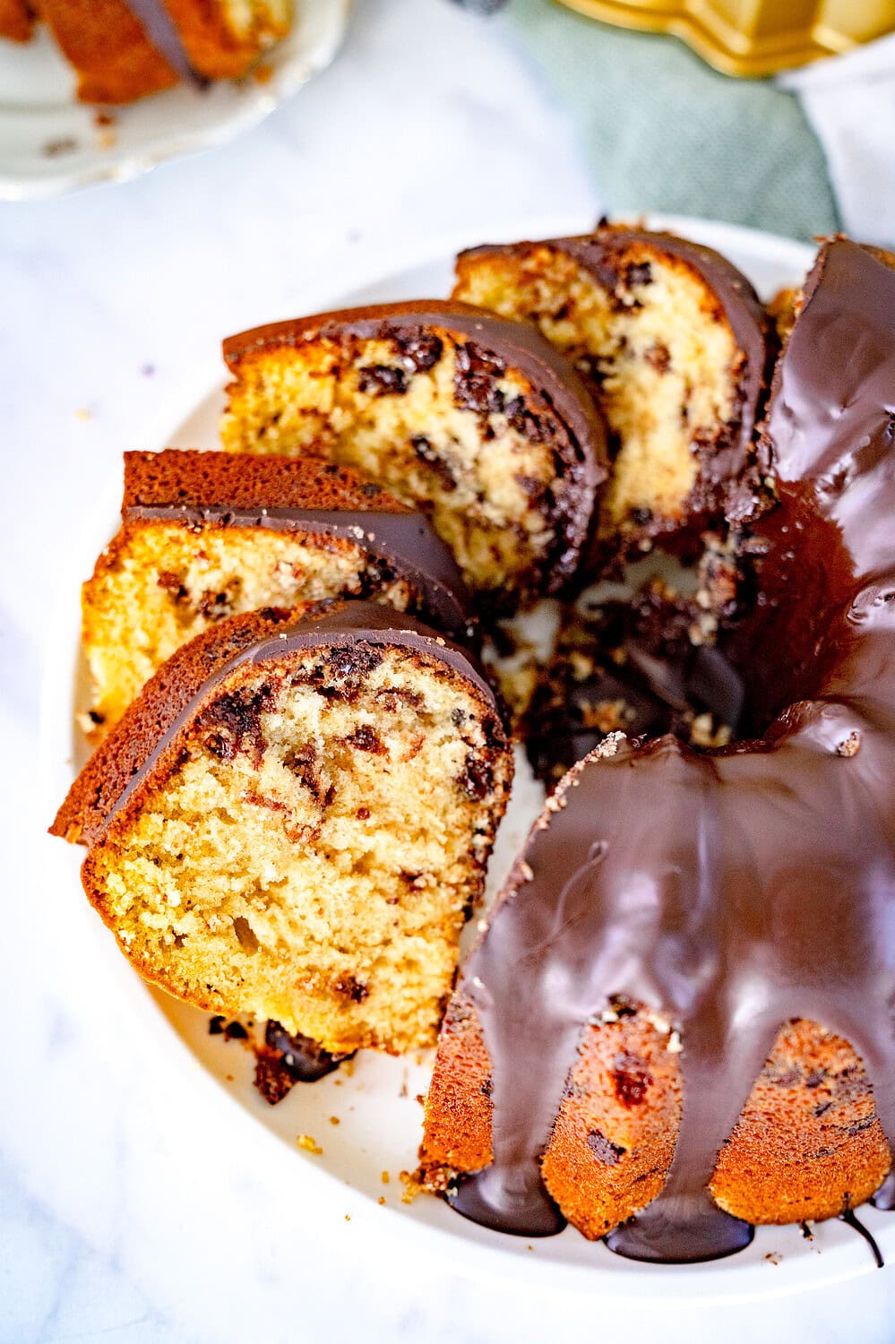 Angeschnittener Chocolate Chip Cookie Gugelhupf auf einem Kuchenteller mit Schokoladenglasur