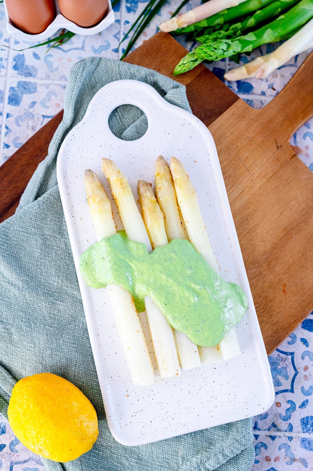 Sauce Tartare zu weißem Spargel schnell und mit Bärlauch und Petersilie auf einem länglichen weißem Teller auf einem Holzbrett