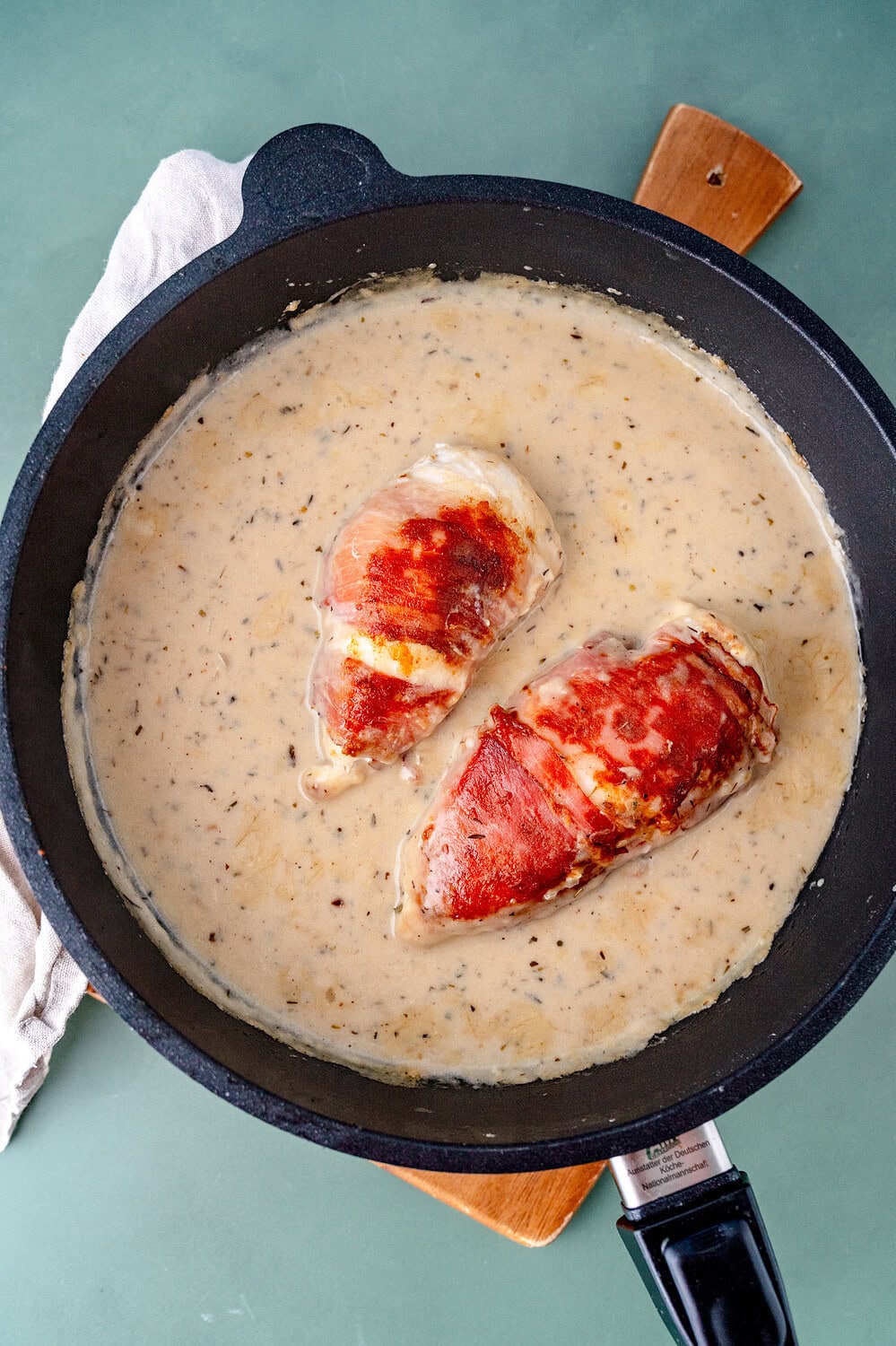 Hähnchen in Bacon in einer parmesansauce in einer Pfanne